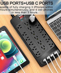 18 Outlet Surge Protector Power Strip With 6 Feet Flat Plug Heavy Duty Extension Cord 2100 Joules Surge Protection 4 USB Ports Black Overload Protection Ideal For Computer Desks And Home Office, top view on desk