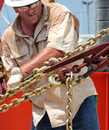 Man using Beefy Ratchet Chain Binder With 2600 Pound Load Capacity LDR 14, 7/8 Inch Screw Diameter, 4 Inch Take Up in industrial setting