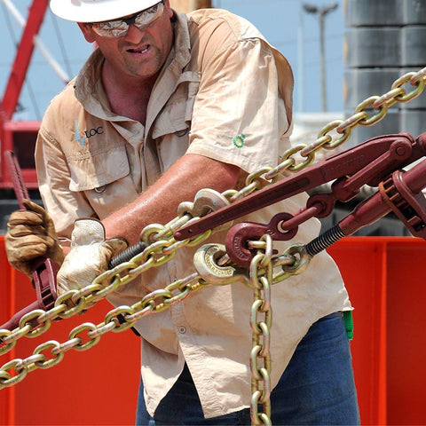 Man using Beefy Ratchet Chain Binder With 2600 Pound Load Capacity LDR 14, 7/8 Inch Screw Diameter, 4 Inch Take Up in industrial setting