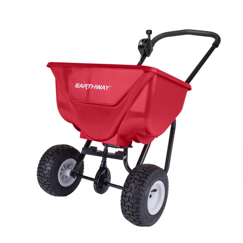 Red Commercial Walk-Behind Broadcast Spreader with 65 lb Capacity for Grass Fertilizer and Seeds, side spread control, and 10 inch pneumatic tires.