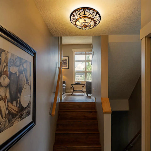 Tiffany Style Ceiling Light With Stained Glass Vibe 2 Light 12 Inch Flush Mount illuminating hallway with artwork.