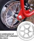 Close-up of Mini Bike Hydraulic Brake Kit 180mm Disc Rotor on wheel, showcasing red caliper arm and rotor details.