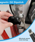Hand inserting magnetic oil dipstick into engine, showing metal shavings collected.