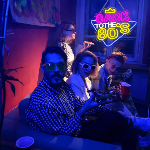 Group of people in a room with a "Back to the 80s" neon sign on the wall, cool tones and retro vibes.