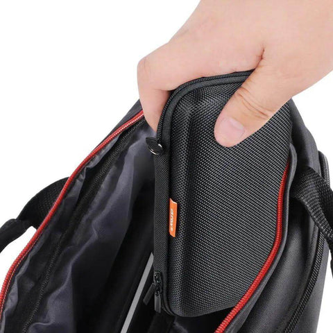 Hand holding a sleek black travel pouch from a backpack, showcasing the Premium Hella Tough Hard Eva Protective Travel Pouch With Slick Mesh Pocket Black Go Anywhere Heavy Duty Carry Case For Power Banks Phones And External Drives.