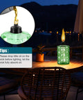 Outdoor Table Top Torch Set With 12 Oz Refill Canisters And Wicks Green Patio Torches For Luau Parties And Garden Decor DIY Backyard Lighting Includes Covers 4 Pack For A Lit Backyard Nighttime Vibe on a wooden table at night