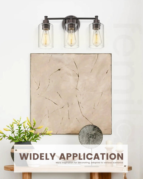 Three Light Vanity Light Fixture For Farmhouse Bathroom With Metal Wall Sconce Clear Glass Shades Oil Rubbed Bronze Finish E26 Base Socket LED Compatible Incandescent Friendly Durable Rustic Modern Look above a textured art piece.