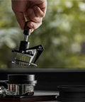 Kickstart Your Daily Grind With This Hella Sharp 58mm Needle Distributor And Wdt Espresso Tool held over a portafilter.