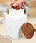 Hand placing a snack into Sweet Matte White Glass Jars With Smooth Bamboo Lids Rock Solid Airtight Food Storage Containers For Kitchen Coffee Beans Cereal And Spices Organization 1800Milliliter Two Piece Bundle.