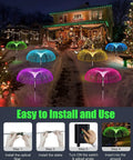 Solar Jellyfish Garden Lights Set Of 5 illuminating a snowy pathway with color-changing LEDs during Christmas at night.