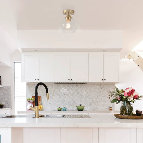Harrow 1 Light Semi Flush Mount Ceiling Light In Matte Brass With Clear Glass Shade in a modern kitchen setting.