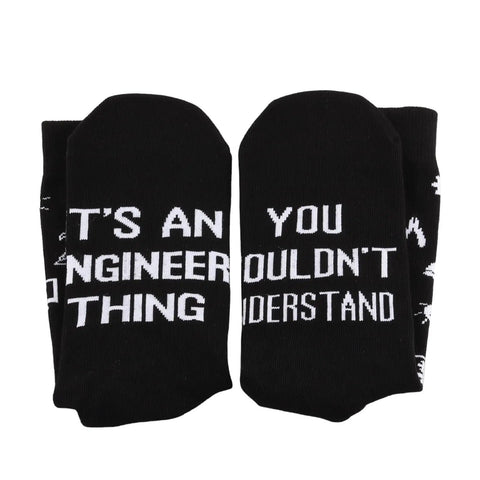 Black socks with white text reading 'Its An Engineer Thing You Wouldnt Understand Socks Funny Novelty Gift For Civil And Mechanical Engineers'.