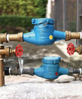 No Fuss Cast Iron Faucet Handle With Bold Red Wheel Grip on plumbing fixture, showing blue valves and red handles.