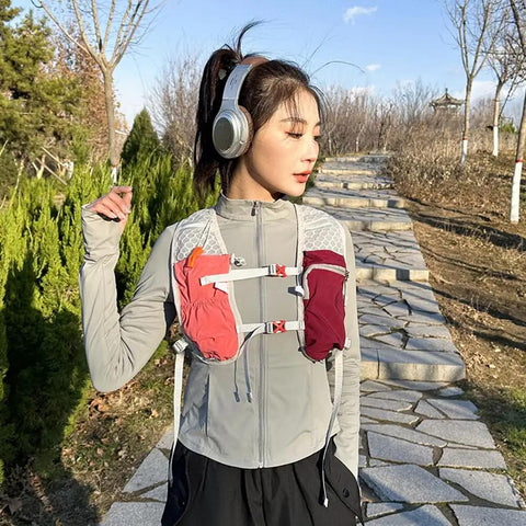 Lightweight Running Vest Hydration Backpack With Breathable Mesh Back Reflective Outdoor Daypack in pink worn by woman in nature
