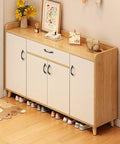 Wooden shoe cabinet with matte black arch handles in a modern hallway setting.