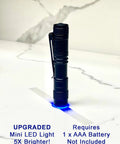 Mini LED flashlight standing on white surface with blue glow, requires 1 AAA battery, labeled as upgraded, next to text.