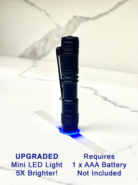 Mini LED flashlight standing on white surface with blue glow, requires 1 AAA battery, labeled as upgraded, next to text.