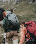 Hikers with Survival Gear Kit For Camping And Emergencies, First Aid Ready Bugout Bag climbing a hillside.