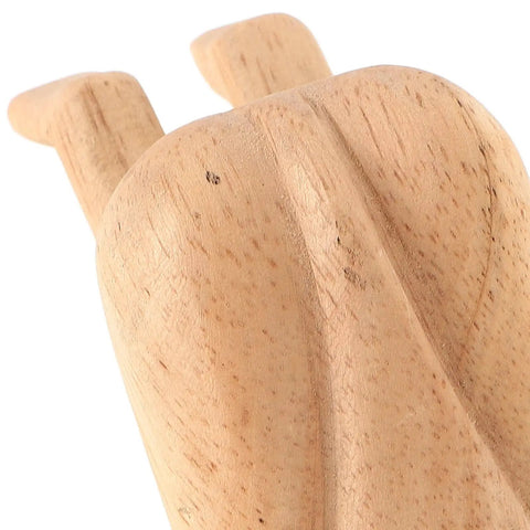 Close-up of a beige wooden door stopper with cute decorative funny shape prevents doors from hitting walls easy to install