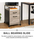 Mobile file cabinet with ball bearing slide next to desk in office setting, featuring wooden drawers and metal frame.