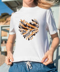 Woman wearing a T-shirt with heart-shaped leopard pattern from Leopard Heat Transfer Vinyl Kit With 16 Sheets 12 By 10 Inch Boho Leopard HTV Animal Print Iron On Vinyl For T Shirts And DIY Craft Projects Make Dope Custom Tees Fast And Easy.