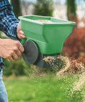 Effortless Hand Crank Seed Spreader 1.5L for Garden and Lawn, Portable Manual Seeder in use scattering seeds evenly