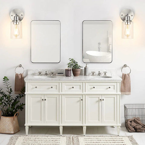 Set Of 2 Modern Brushed Nickel Wall Sconces With Clear Glass Shades For A No Fuss Bathroom Vanity Lighting, Damp Rated Farmhouse Style Wall Lamps For Mirror, Bedroom, Or Hallway, 1 Light above a double sink vanity in a bathroom.