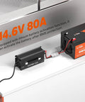 Beefy 80-Amp LiFePO4 Battery Charger For 12V Systems with AC-DC Smart Charging connected to a battery showing 14.6V 80A output