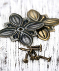 Close-up of 50 Pack Vintage Upholstery Nails Heavy Duty Iron Decorative Tacks showing antique brass finish and flower-shaped decorative tacks.