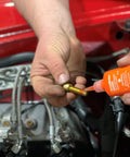 Orange Hybrid Strength Removable Threadlocker For High Torque Hold Delivers Three Times The Prevailing Torque Of Blue Threadlocker While Still Allowing Fasteners To Be Disassembled Perfect For Prolonged Vibration And Heavy Duty Assemblies 10 Ml being applied to engine bolt