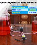 Compact Electric Water Transfer Pump With Top Shelf Food Grade Hoses and Plug And Play Adjustable Speed Settings For A Steady Two Liter Per Minute Stream During Quick 110 Volt Hookups on a table with liquids.