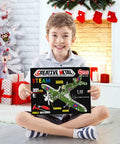 Child holding box of Build Your Own Hurricane Fighter Plane Kit With 331 Metal Parts In 1:32 Scale, seated by festive decor.