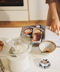 Stainless Steel Kitchen Timer With Magnetic Base, Compact 3.1 Inch Dial on kitchen countertop beside baking ingredients and cookbook
