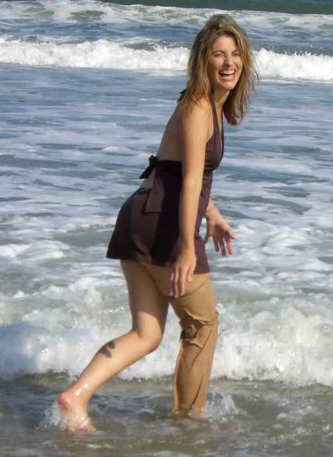 Woman wearing Waterproof Prosthetic Leg Cover For Swimming And Shower, Airtight Submersible Sleeve, enjoying ocean waves.