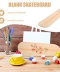 Blank Unfinished 7 Ply Wooden Skateboard Deck With Double Tail For Art Painting And DIY Custom Builds displayed on a table with art supplies.