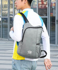 Person wearing Ultra Lightweight Daypack Water Backpack for Camping, Hiking, Climbing and Riding, grey color, wide straps