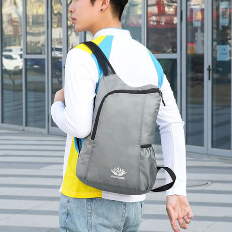 Person wearing Ultra Lightweight Daypack Water Backpack for Camping, Hiking, Climbing and Riding, grey color, wide straps