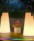 Rechargeable Cordless Outdoor Lanterns With Dope RGB Colors on a wooden table, glowing with warm light, perfect for garden use