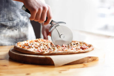 Pizza Cutter Roller Wheel With Sharp Blade For Crusts And Pies cutting pizza on wooden board