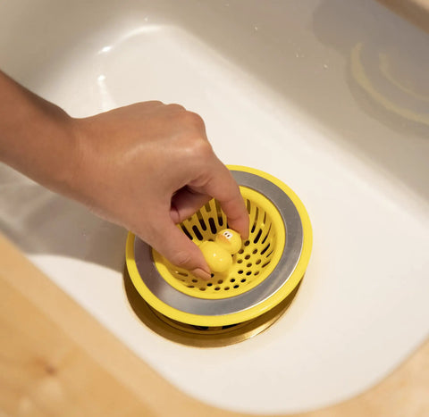 Hand placing Quack Duck Kitchen Sink Strainer Basket Fits All Standard Sinks 4 And A Half Inch Stainless Steel Drain Cover in sink.