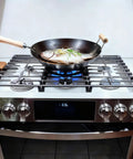 Cast Iron Wok Ring Support For Gas Stoves Non Slip Replacement Grate in use with fish cooking in wok on gas stove.
