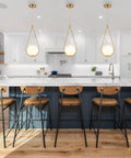 Kitchen island with Cool Satin Brass Glass Globe Pendant Light and frosted milk glass shades in modern farmhouse style.