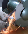 Hands using Heavy Duty 6 Inch Bench Grinder Wheels 80 Grit White Aluminum Oxide Vitrified Ceramic Stones for sharpening.