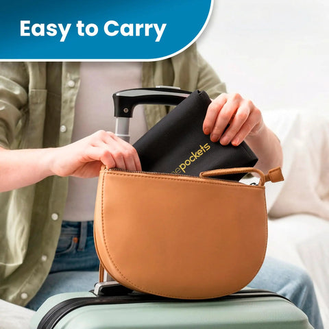Person packing black Air Travel Tray Cover And Seat Back Organizer For Flights, The Ultimate In Flight Organizer into handbag on luggage.
