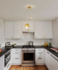 IPEDWO 2-Light Modern Gold Pendant Lights, Light Fixture for Kitchen Island over a stylish black countertop in a contemporary kitchen.
