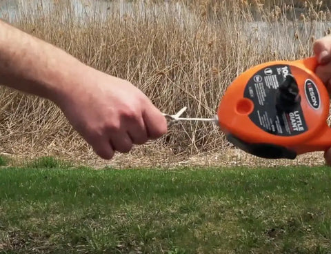 Person using Pro Grade Chalk Line Reel With 110 Foot Reach, 12 Ounce Chalk Capacity, Extra String, outdoor setting