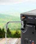 Portable Propane Water Heater And Shower Pump For Camping And Outdoors, side view showing water outlet and flowing water