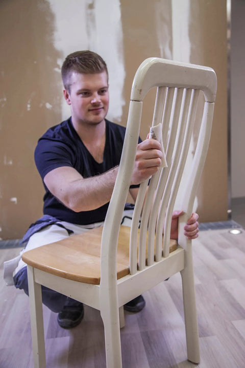 Person sanding a chair with Soft Hand Sanding Sheets 4.5 By 5 Inch Grit 240 On Perforated Roll 200 Sheets A Weight Latex Backing Flexible