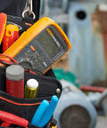 Pro Grade True RMS Digital Multimeter Kit with Premium Leads and ToolPak hanging at job site, showing rugged protection.
