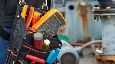 Pro Grade True RMS Digital Multimeter Kit with Premium Leads and ToolPak hanging at job site, showing rugged protection.